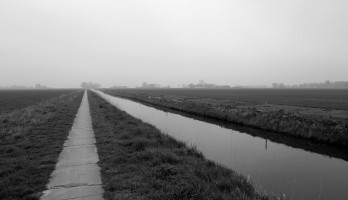 Leeg en grijs, een lange weg door de landerijen, gemaakt door mij Hilde Remerie.