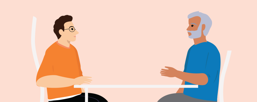 een man zit met hulpverlener aan tafel en praat