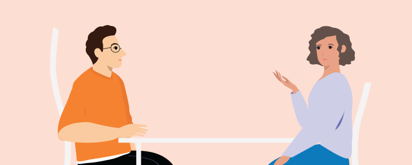 een vrouw zit met hulpverlener aan tafel en praat